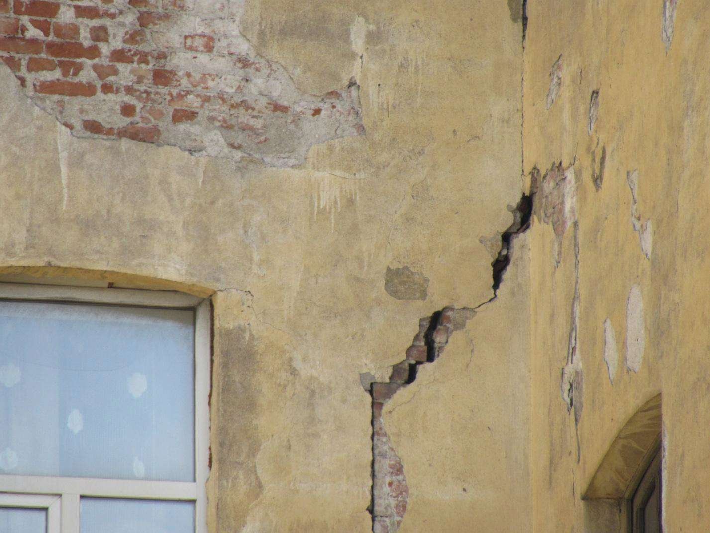 Трещины несущей стены. Трещина в доме. Трещина в здании. Трещины на фасаде. Трещина в стене дома.