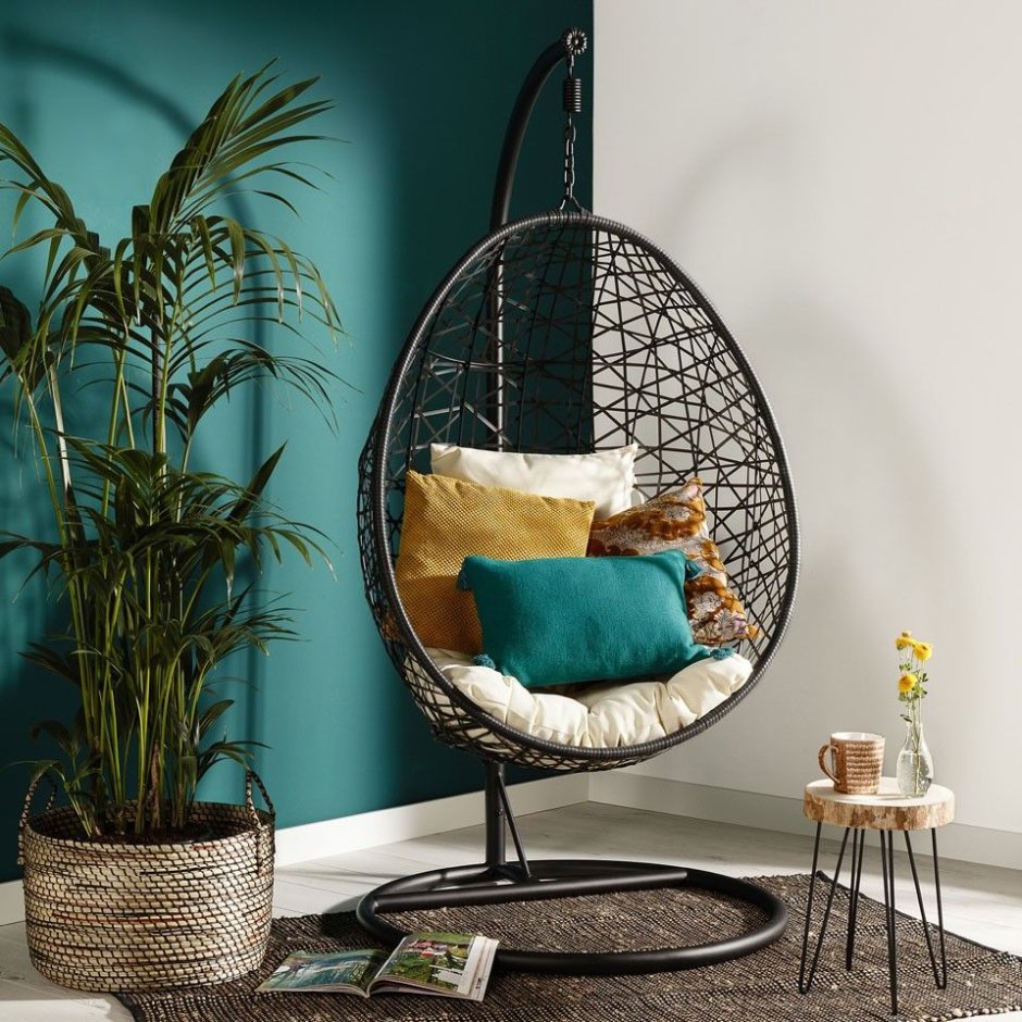 Спальня с зеленой стеной и круглым подвесным креслом