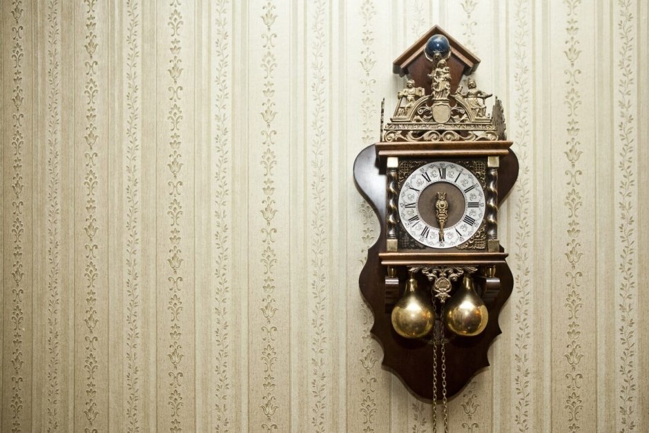 Старинные часы с маятником на кирпичной стене