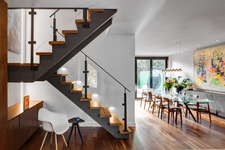 Интерьер гостиной с деревянной лестницей