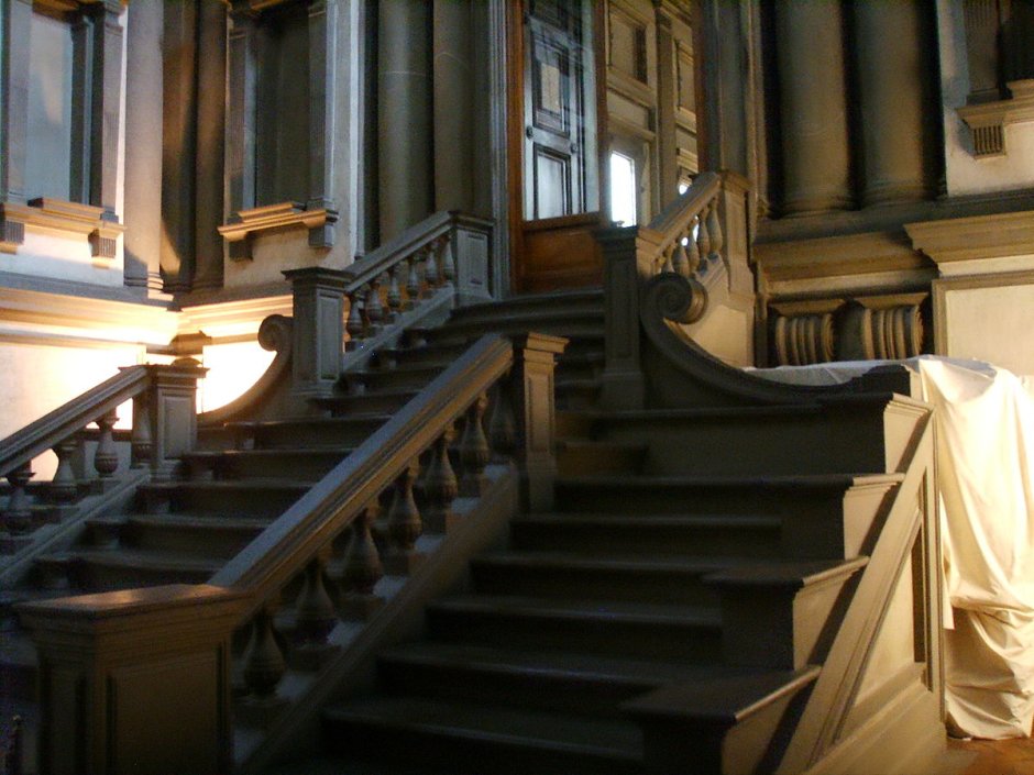 Холл с мраморным полом и деревянной лестницей