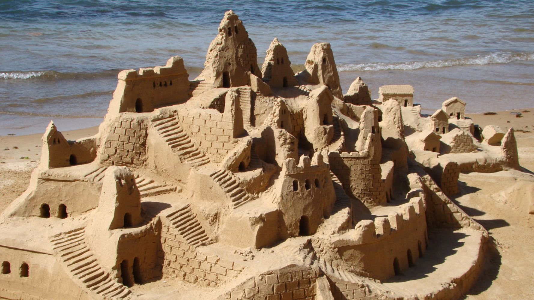 Мальчик строит песочный дом