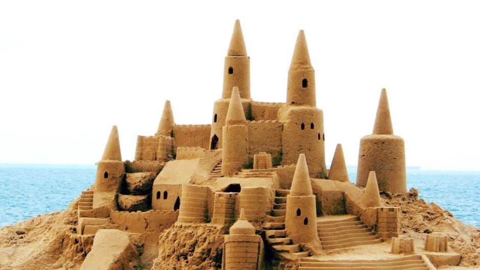Строить замок из песка на белом фоне