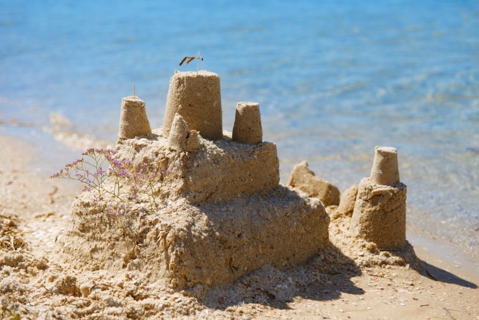 Мужчина строит замок из песка