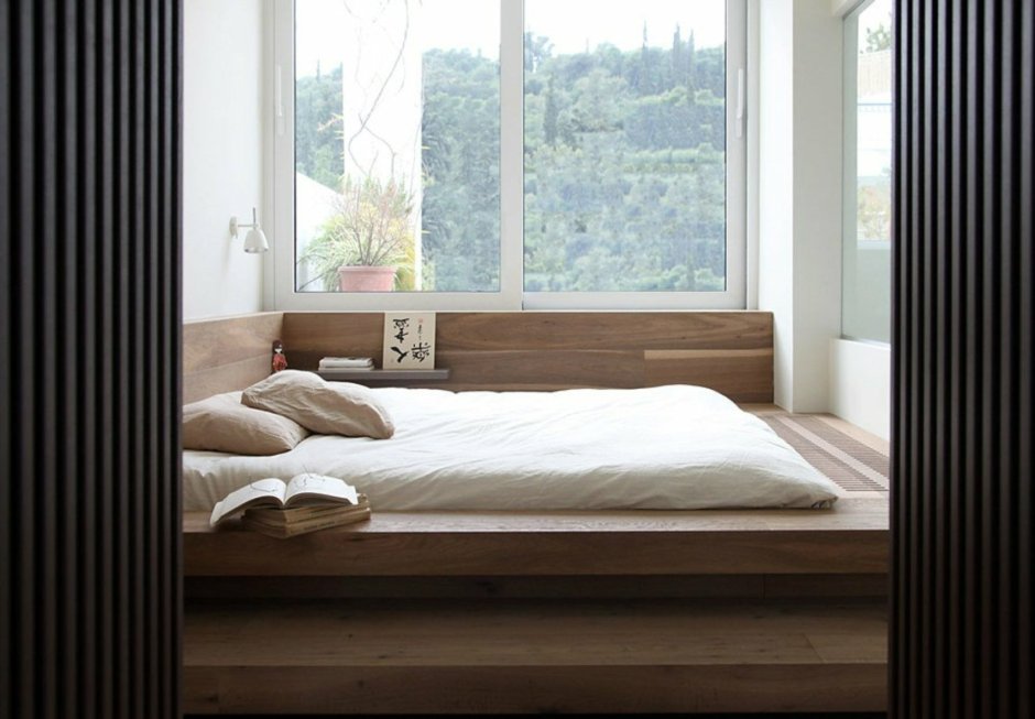 Кровать между окнами в спальне