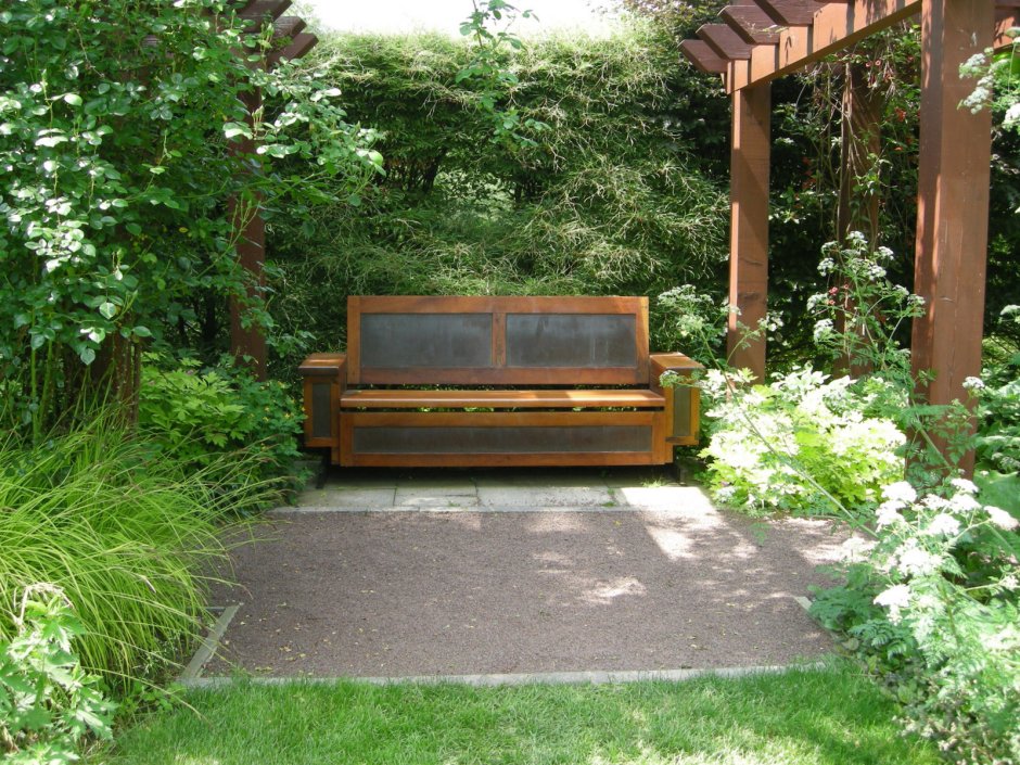 Скамейка у забора в саду