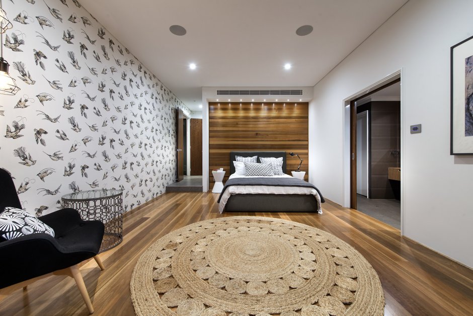 Интерьер спальни с ковром на стене