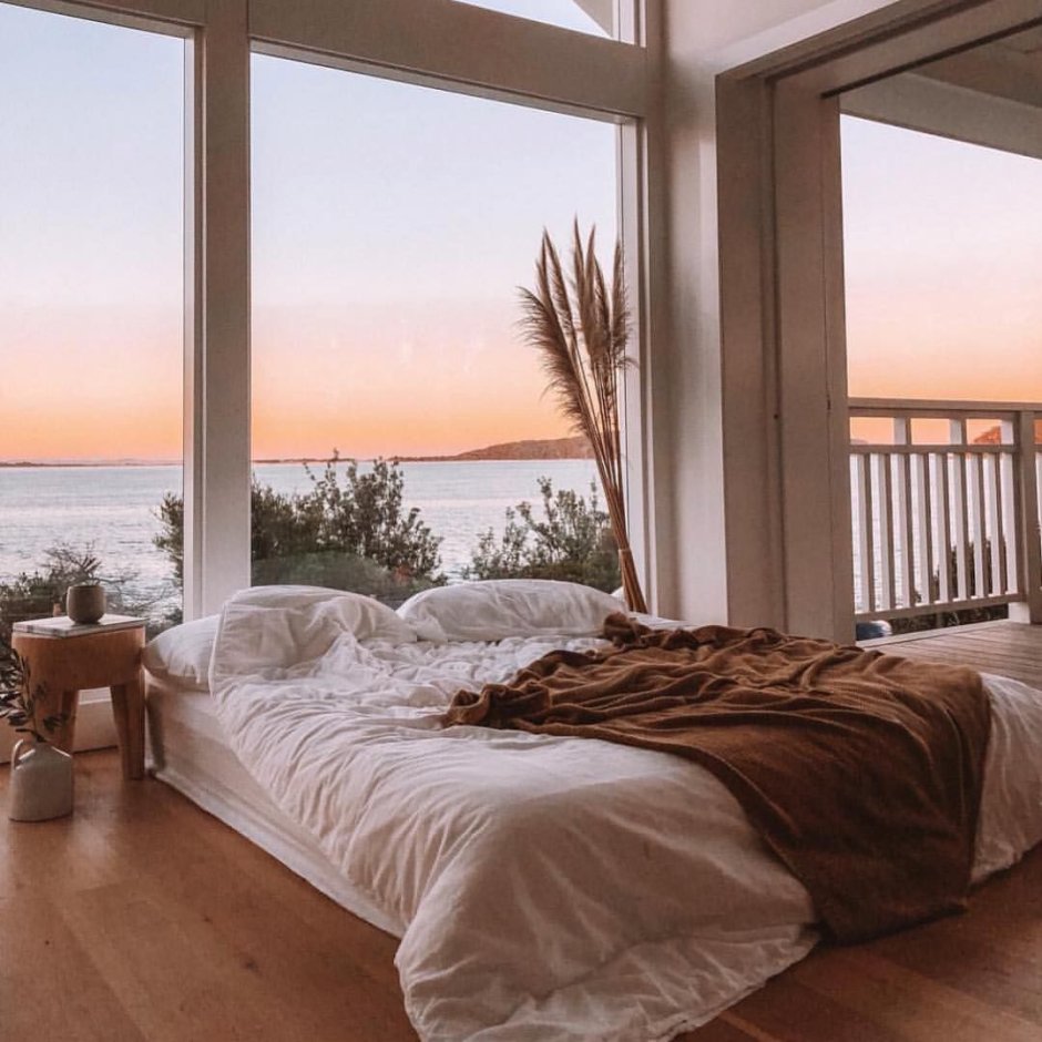Белоснежная спальня с панорамными окнами и видом на океан