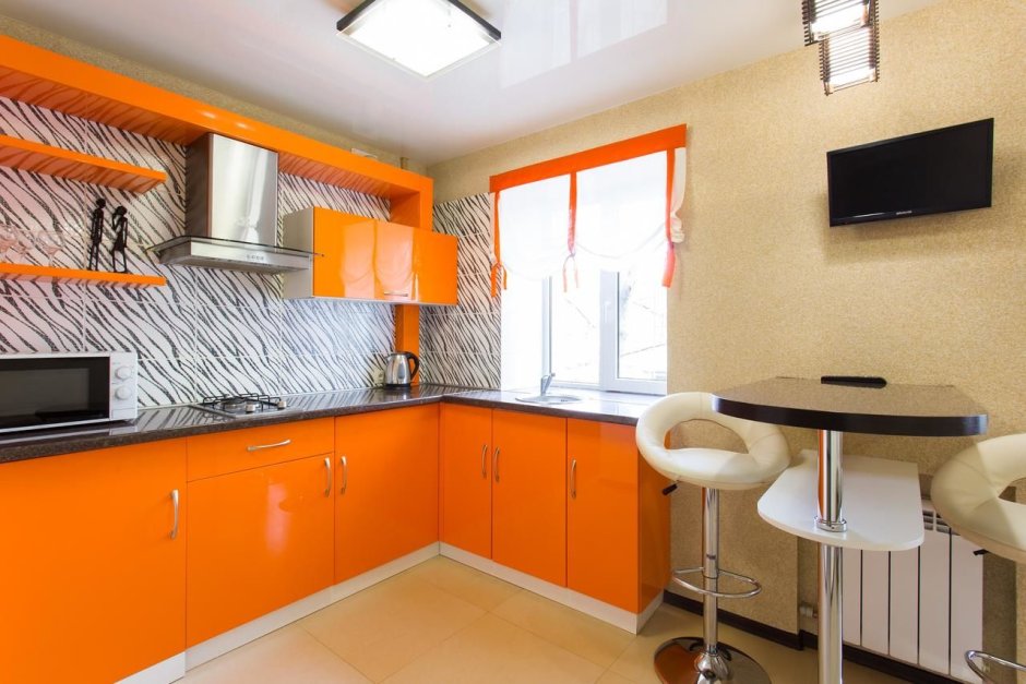 Оранжевая кухня с серыми обоями