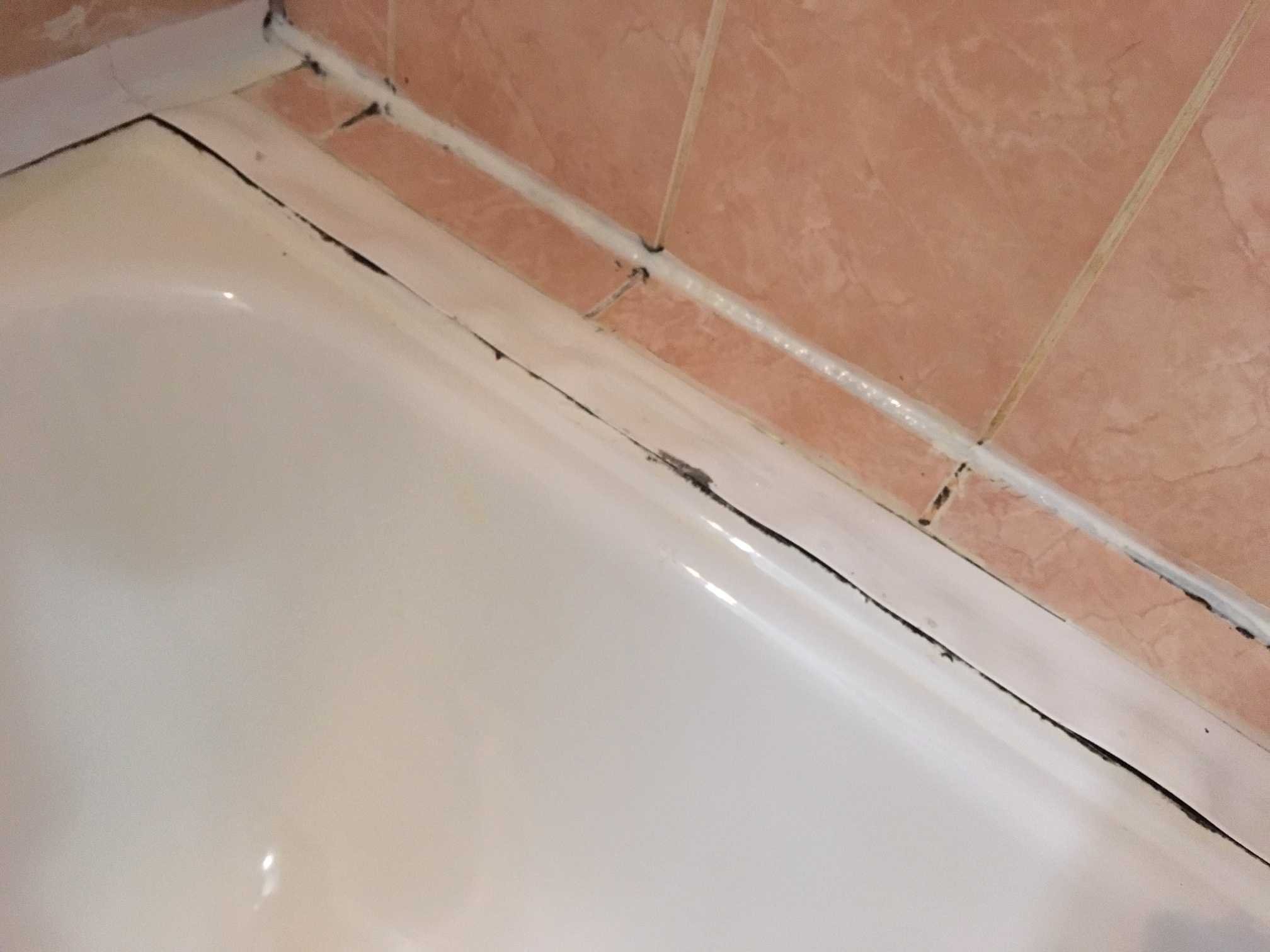 Чем заделать стыки плитки. Заделка стыка между ванной и стеной 10 см. Шов между ванной и стенко. Стык ванны и стены. Шом между стеной и ванной.