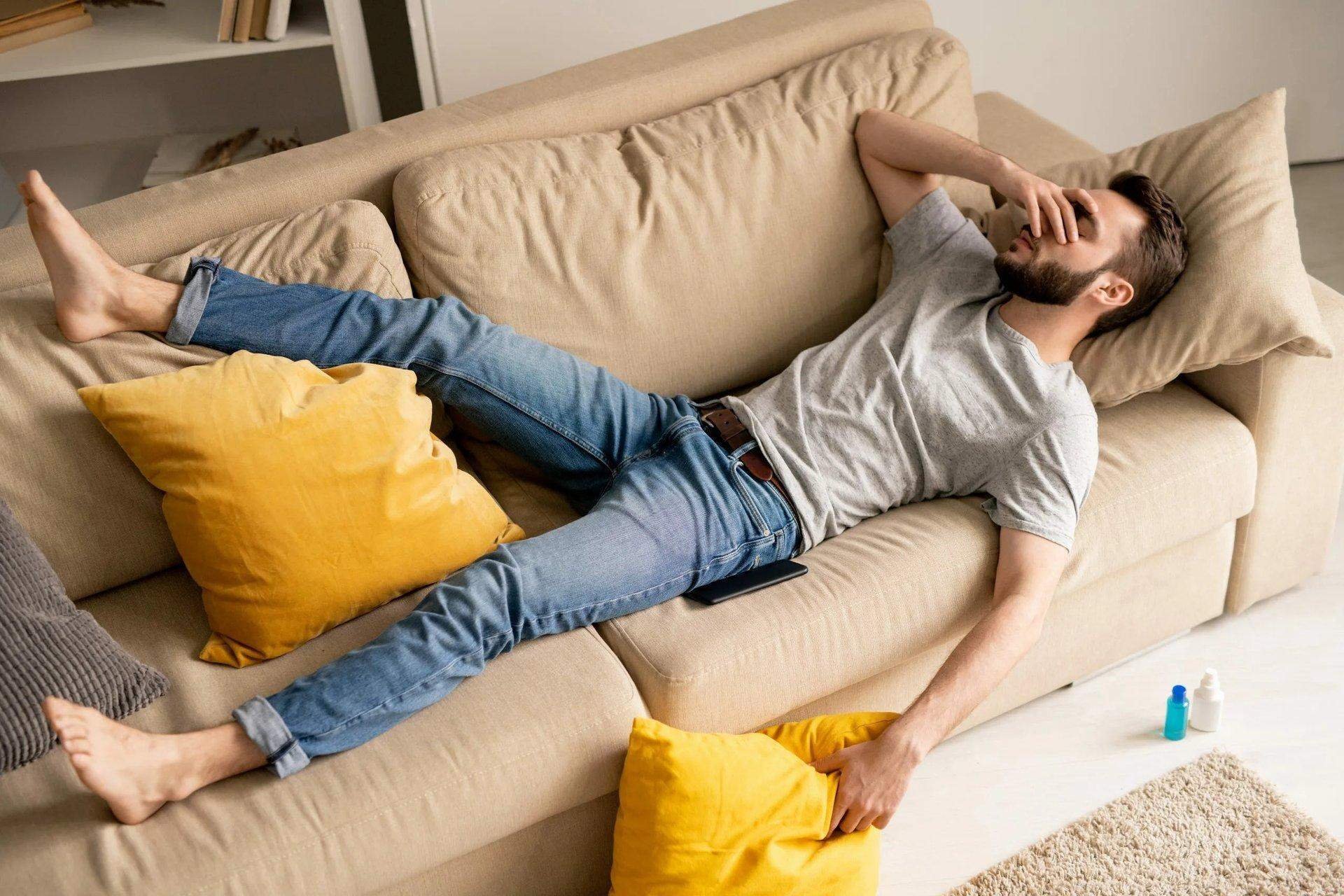 Почему мужчина лежит. Мужчина на диване. Лежит на диване. Человек лежит на диване. Парень на диване.