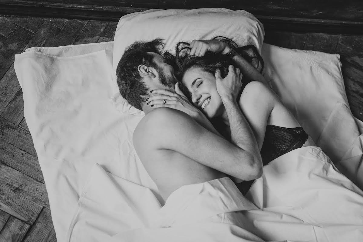 муж и жена целуются в кровати