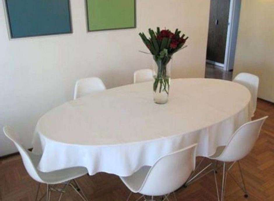 Овальный белый стол в интерьере с салфетками