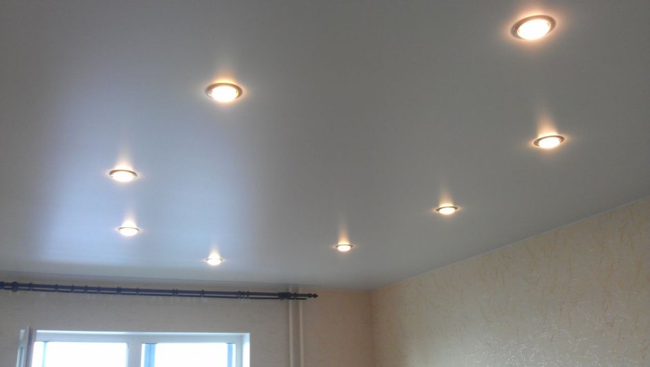 Размещение светильников на натяжном потолке в гостиной