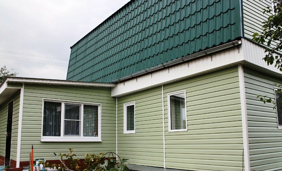 Дом обшитый сайдингом с зеленой крышей