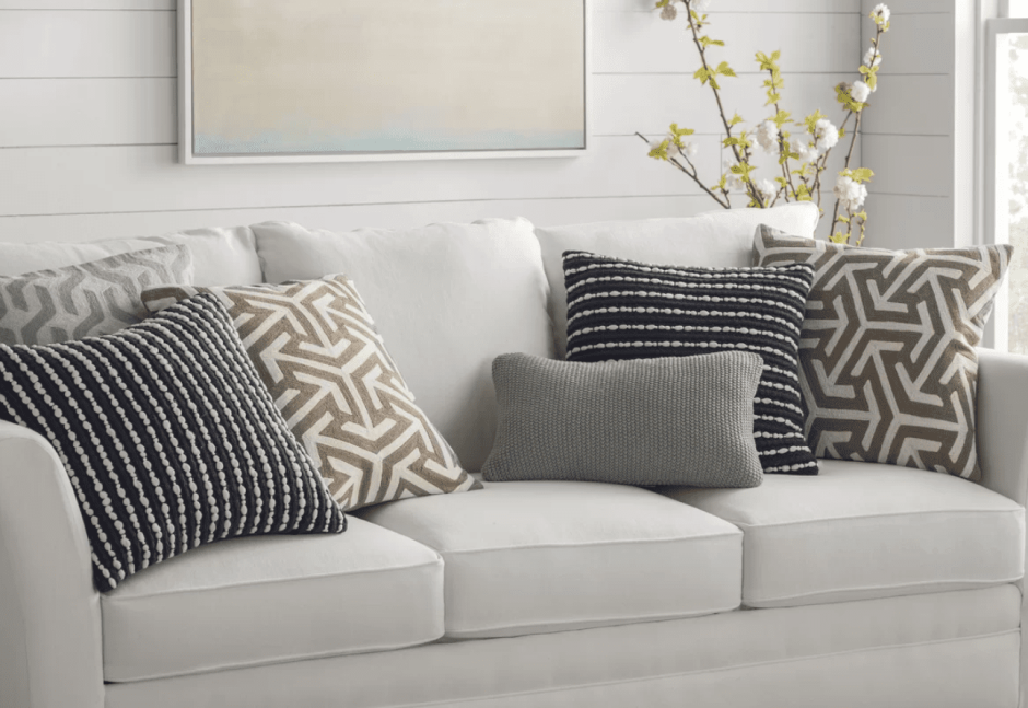 Серый диван с бордовыми подушками