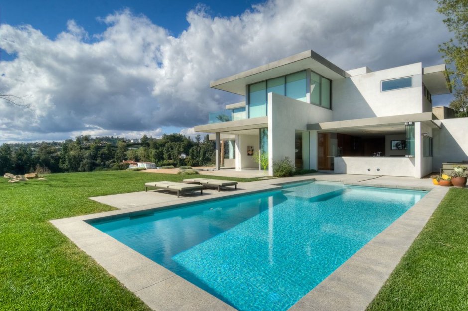 Красивый дом с газоном и бассейном