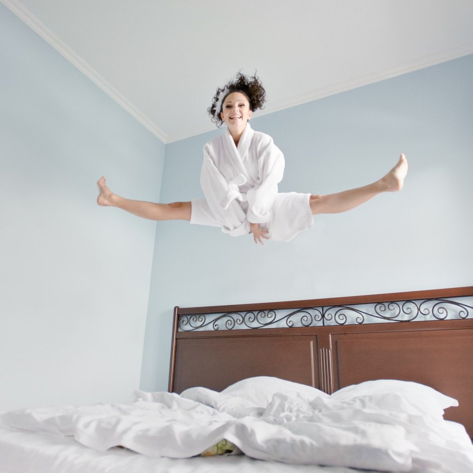 Человек прыгает на кровати