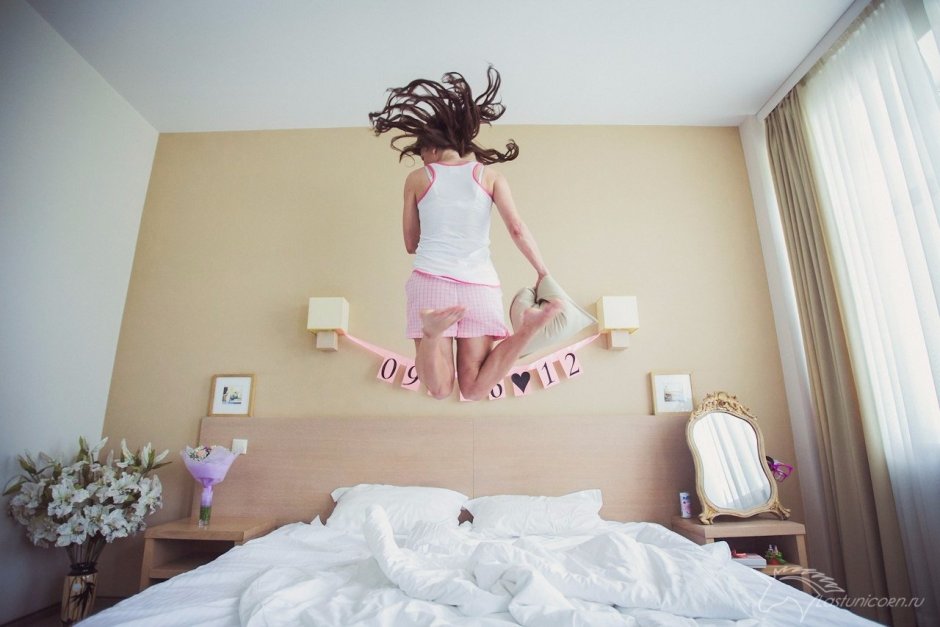 Девочка прыгает на кровати