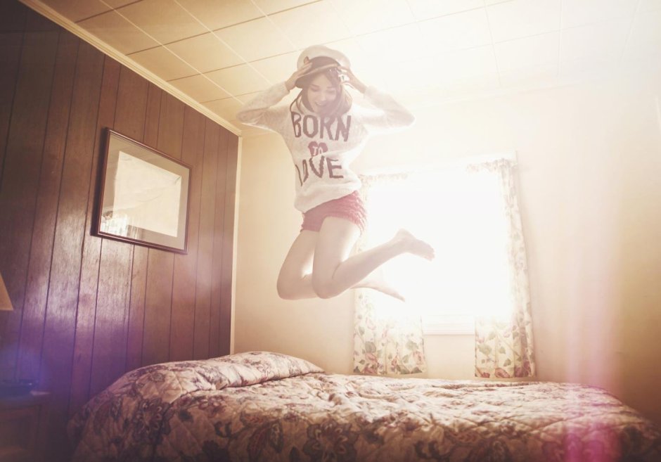 Девушка прыгает в комнате