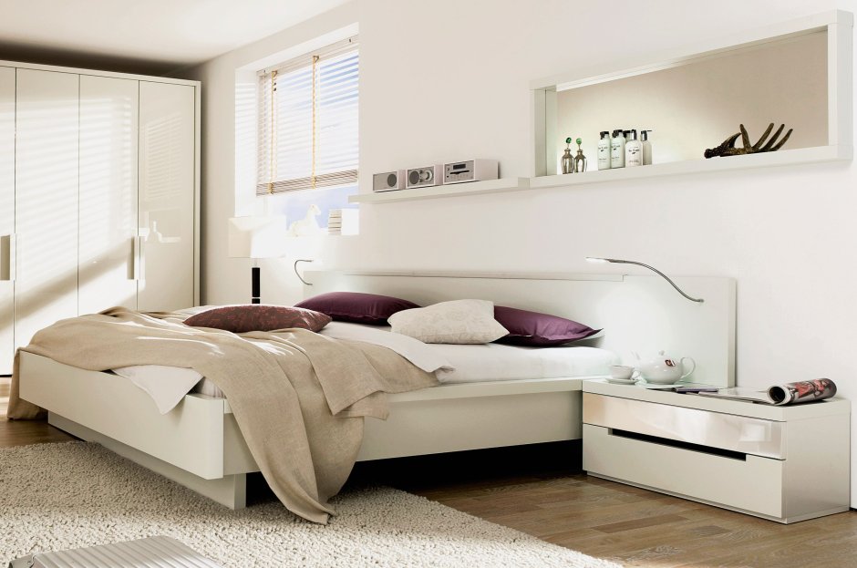 Белая кровать с тумбочками в спальне