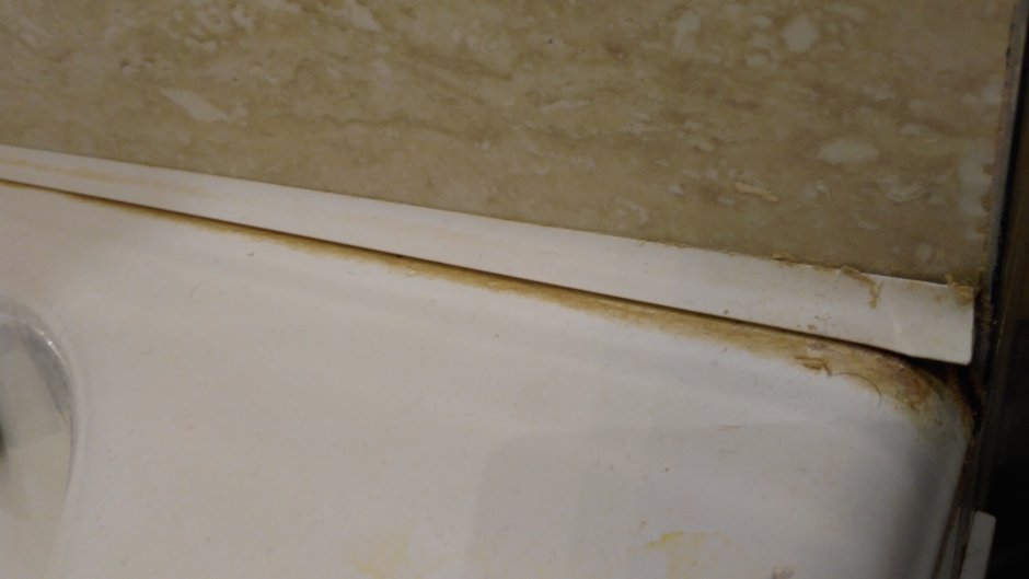 Стык между кафелем и неровный край ванной