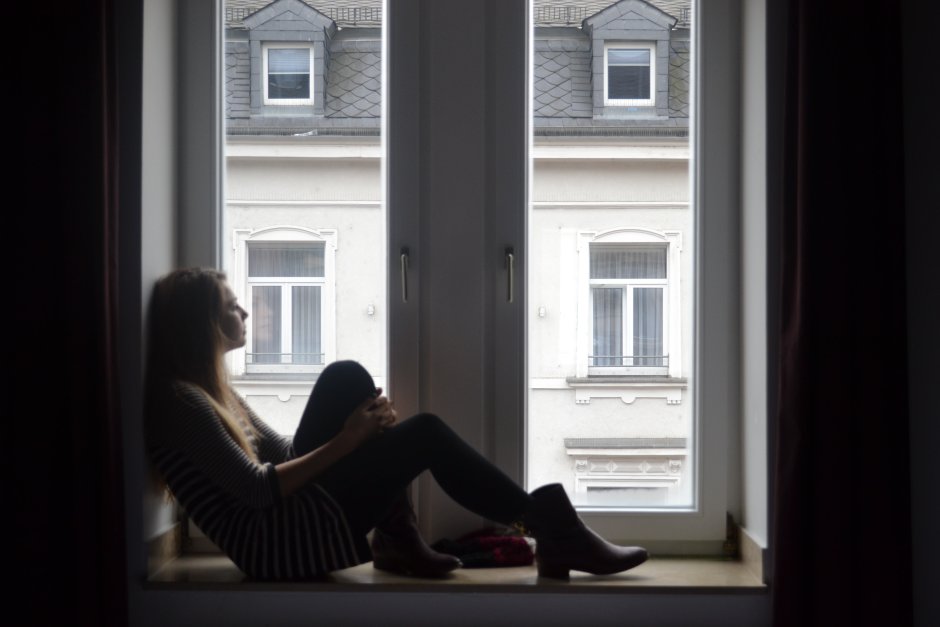 Девушка сидит на окне