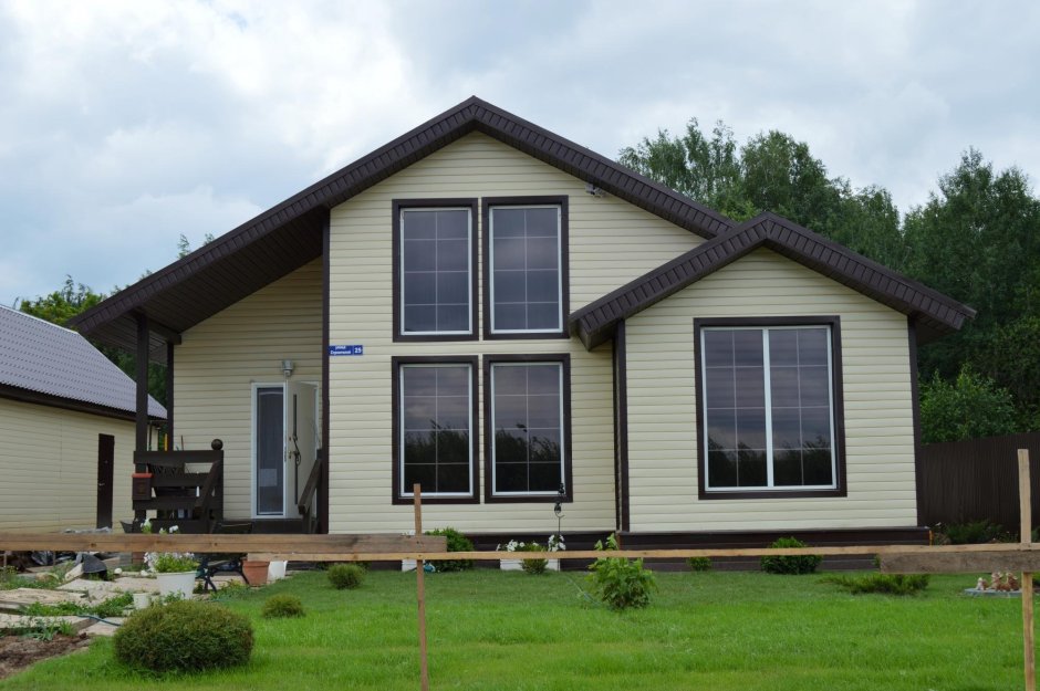 Бежевый дом с коричневыми окнами
