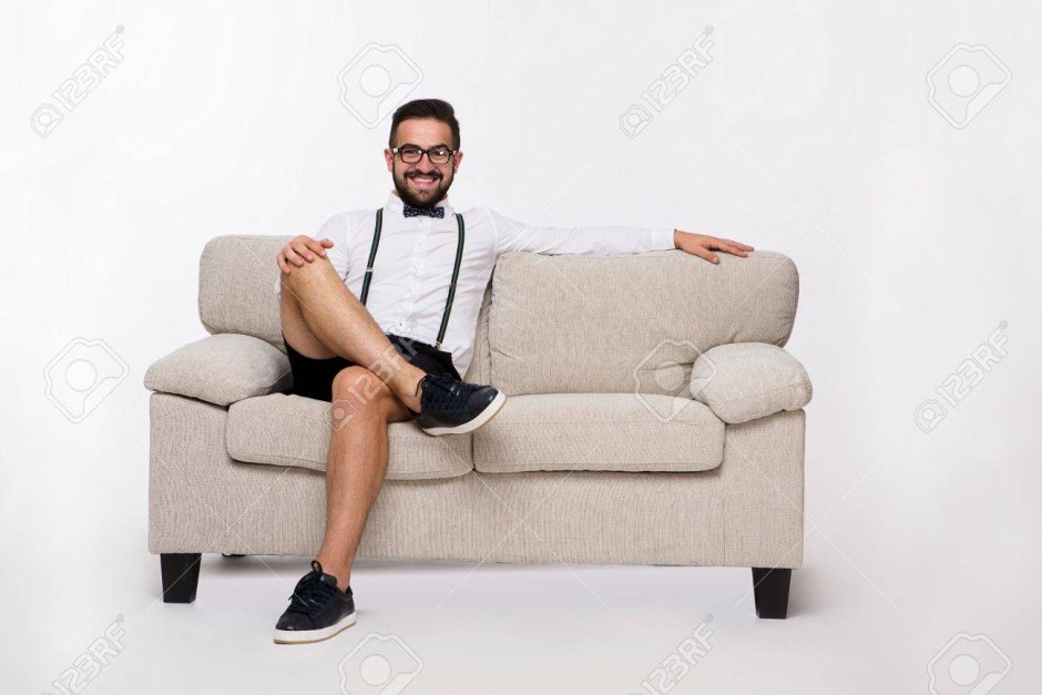 Красивый человек улыбается на диване