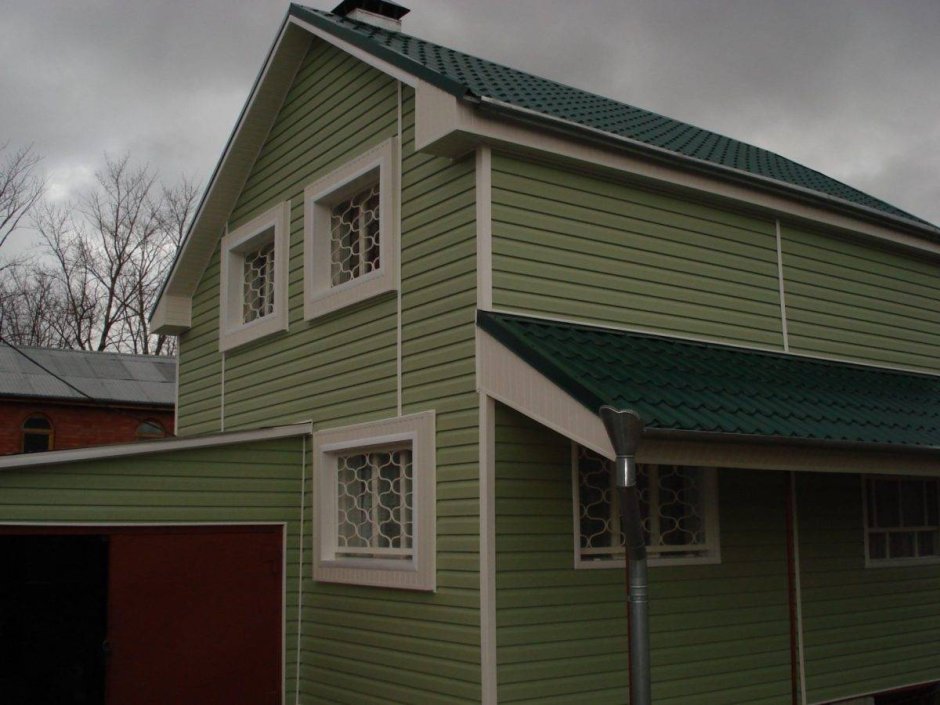 Оштукатуренный дом с зеленой крышей