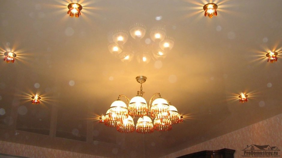 Натяжной потолок с люстрой и точечными светильниками в зале