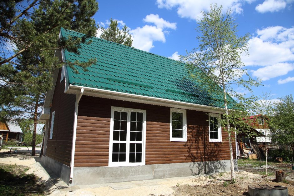 Коричневый дом с зеленой крышей