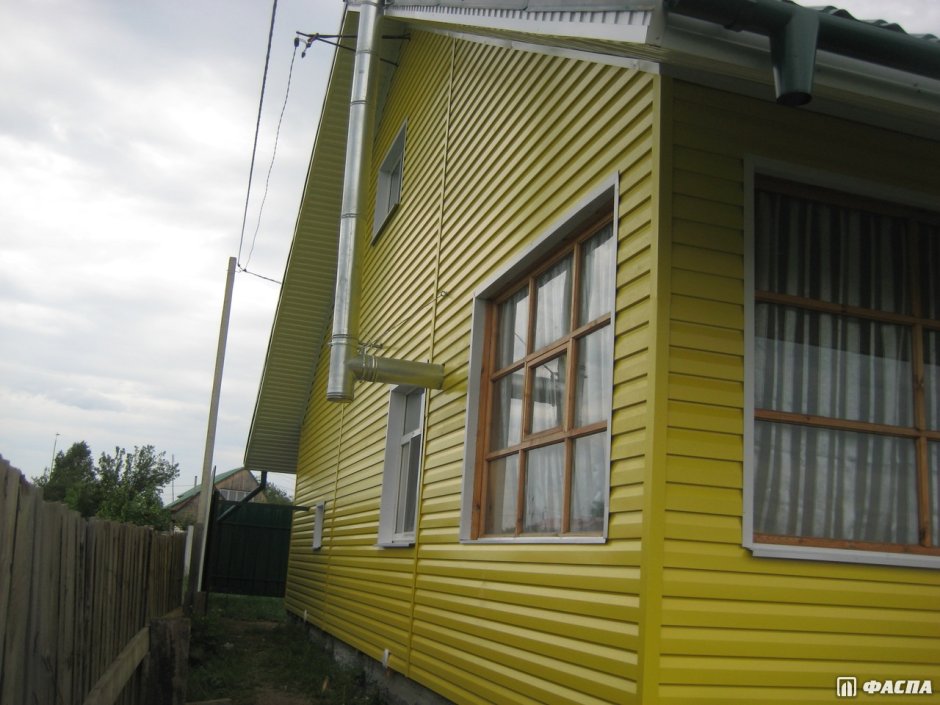 Дом обшитый желтым сайдингом