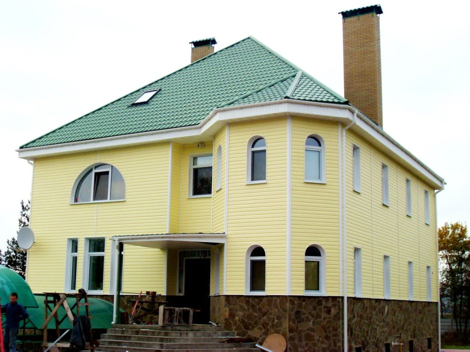 Фасад дома с зеленой крышей