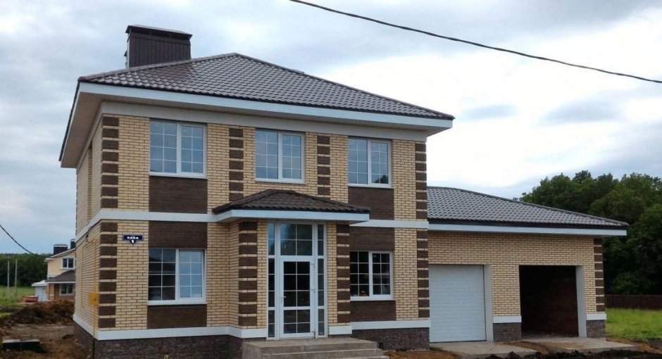 Дом из светлого кирпича с белыми окнами