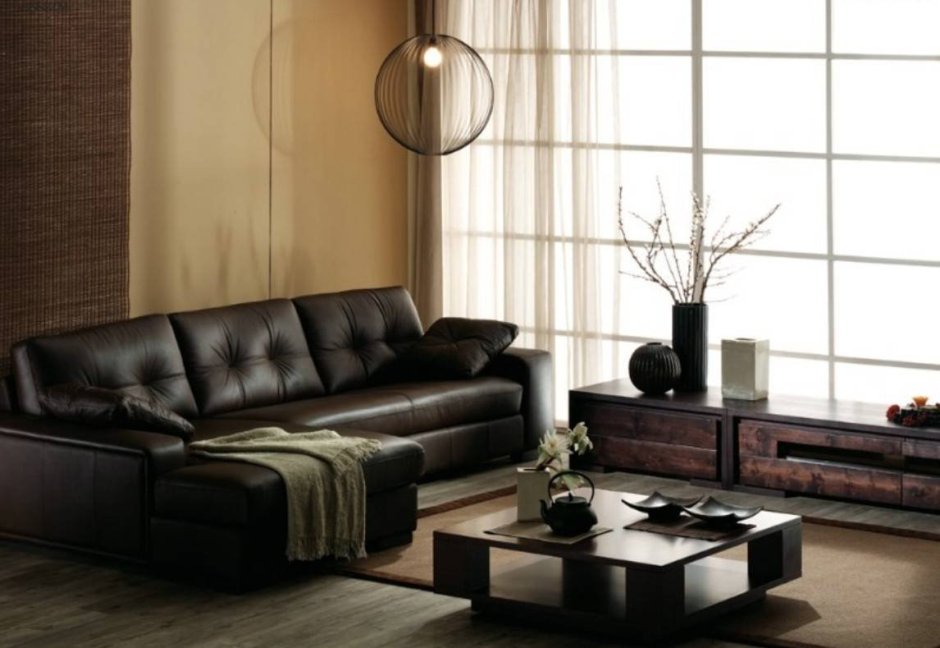 Интерьер гостиной с черным кожаным диваном