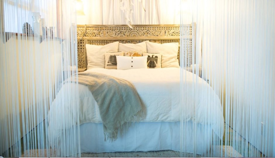 Кровать в спальне с занавеской