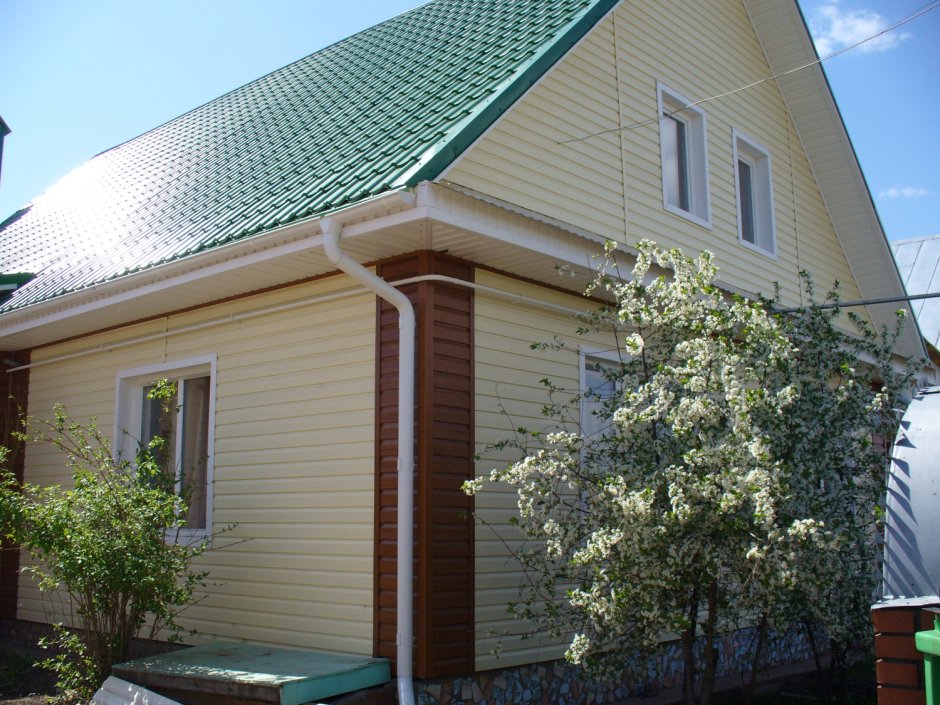 Дом с зеленой крышей отделанный сайдингом