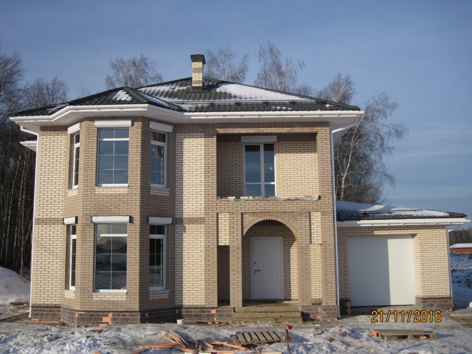 Двухэтажный дом из светлого кирпича