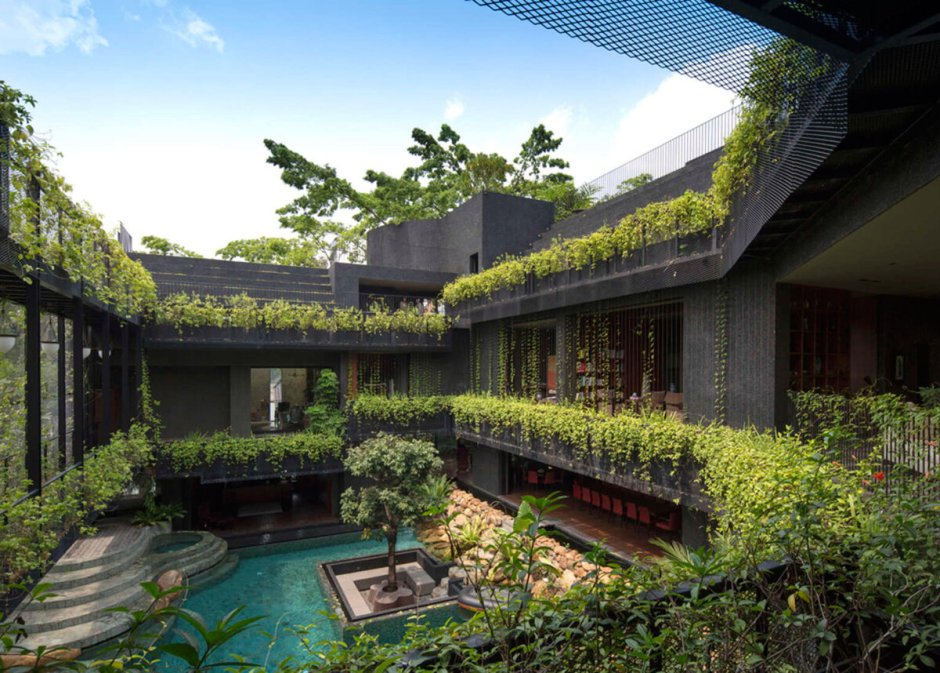 Дом с зеленой крышей и садом