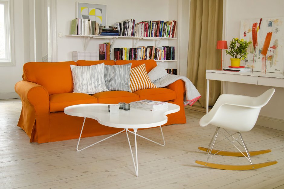 Оранжевый диван на ножках в гостиной