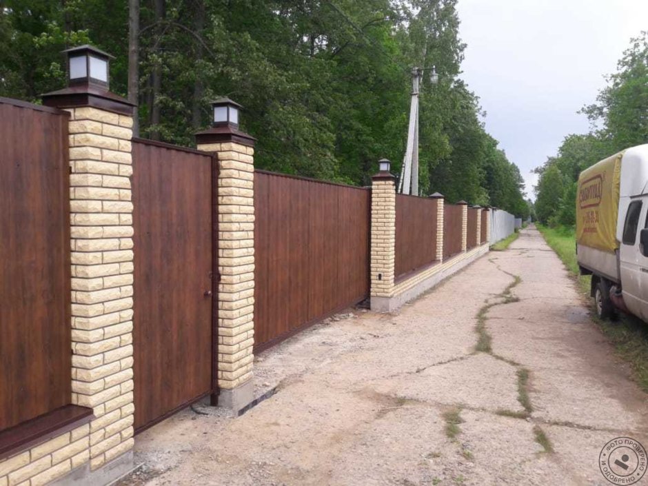 Забор из профнастила под дерево с кирпичными столбами