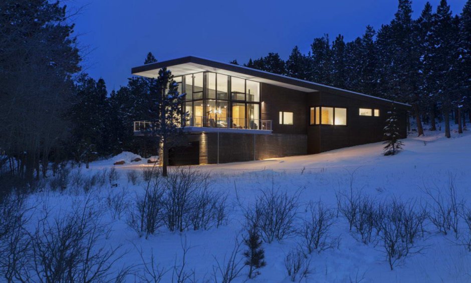 Современный дом зимой в лесу