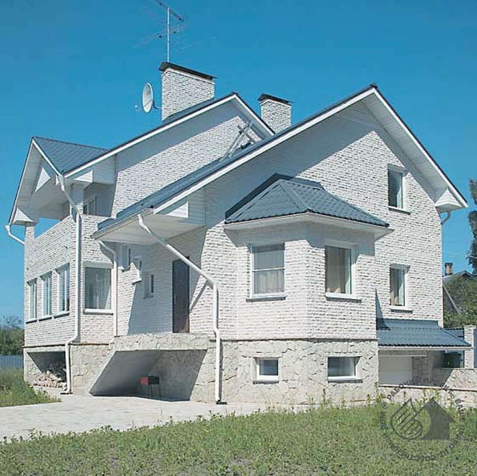 Белый кирпичный дом с серой крышей