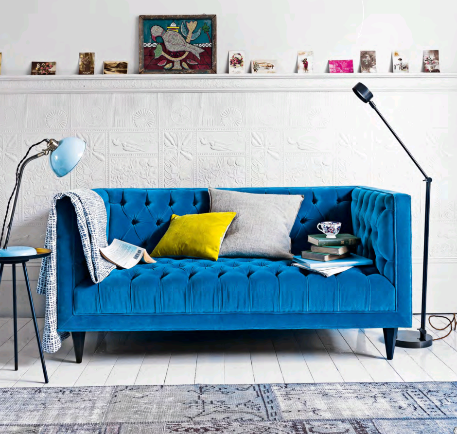 Синий диван с желтыми подушками