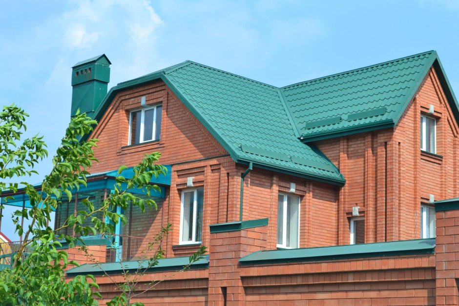 Кирпичный дом с зеленой крышей