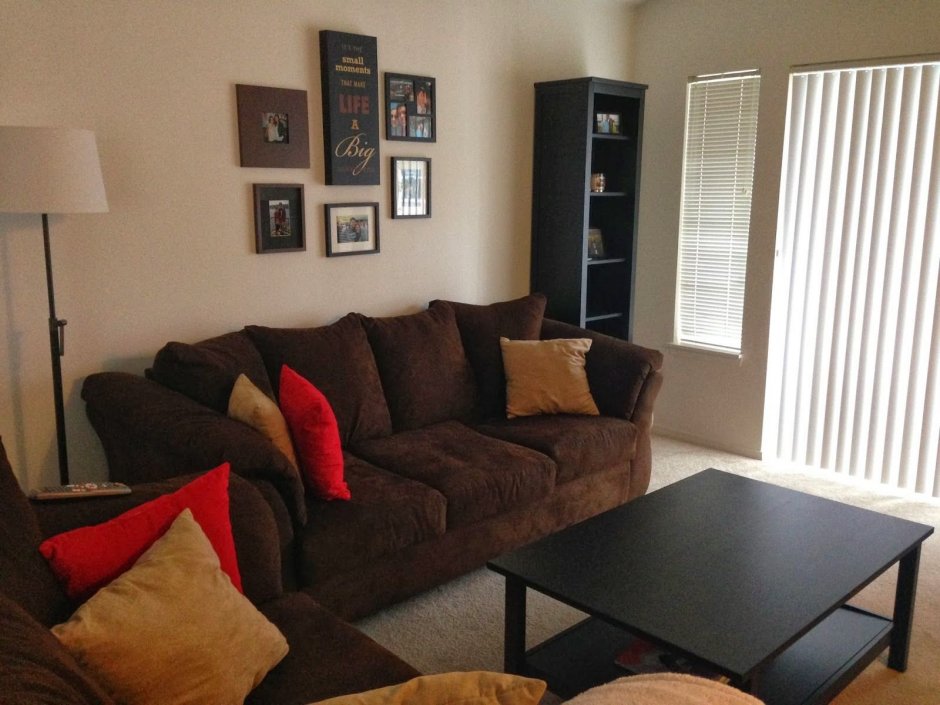 Темно-коричневый диван в интерьере гостиной