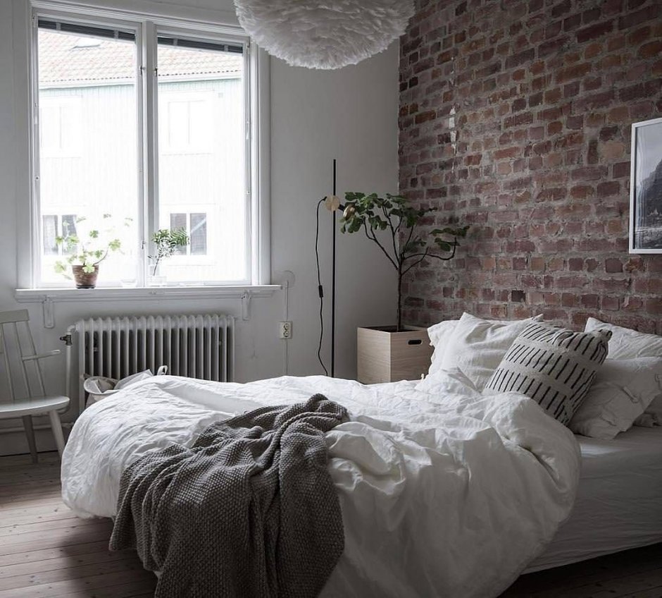 Серо белая спальня с кирпичной стеной
