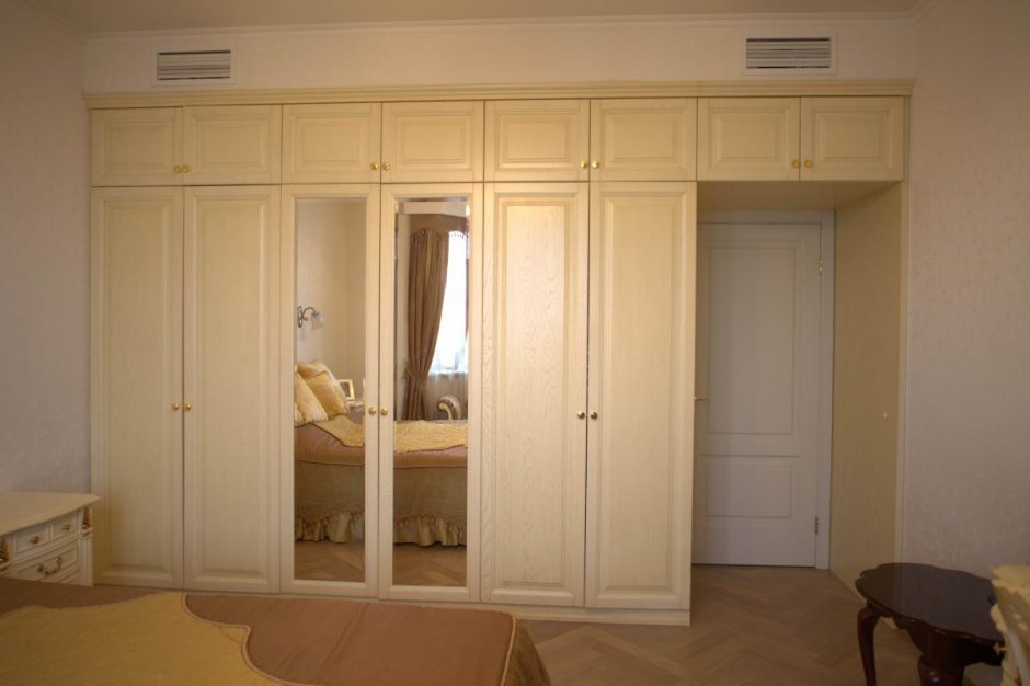Шкафы вокруг двери белые в спальне