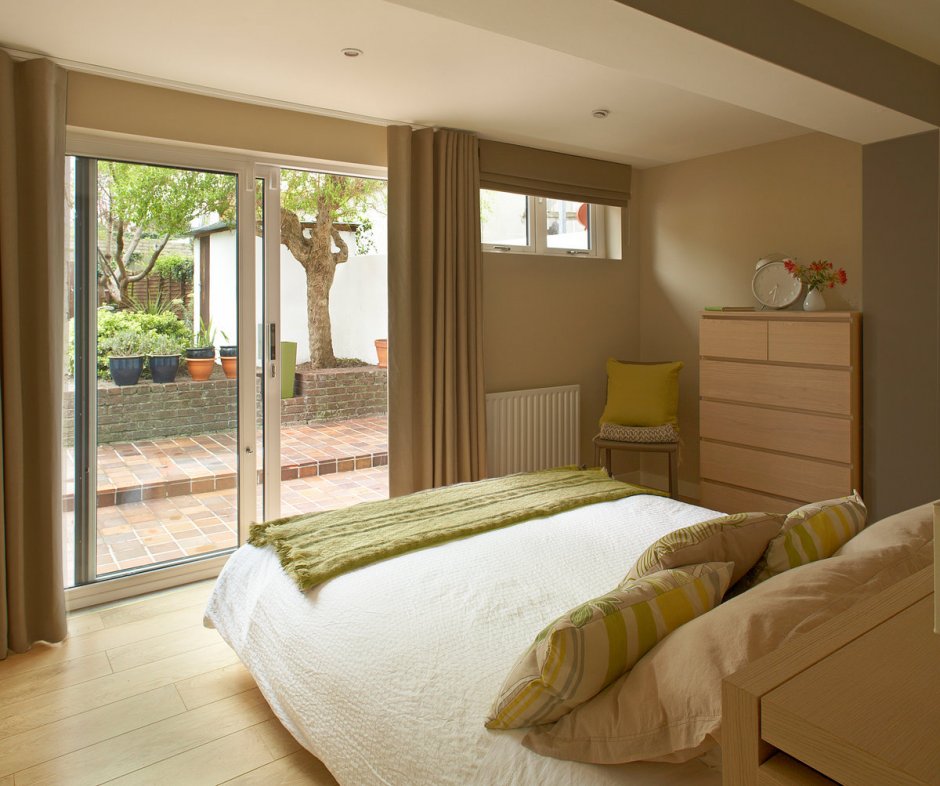 Интерьер спальни в частном доме с двумя окнами